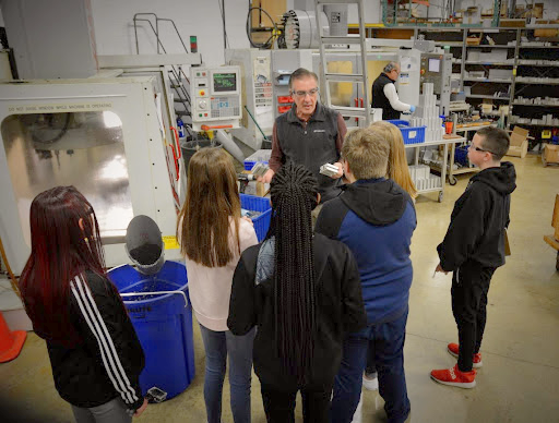 Macron's Tony Cirone showing students the CNC machining operations